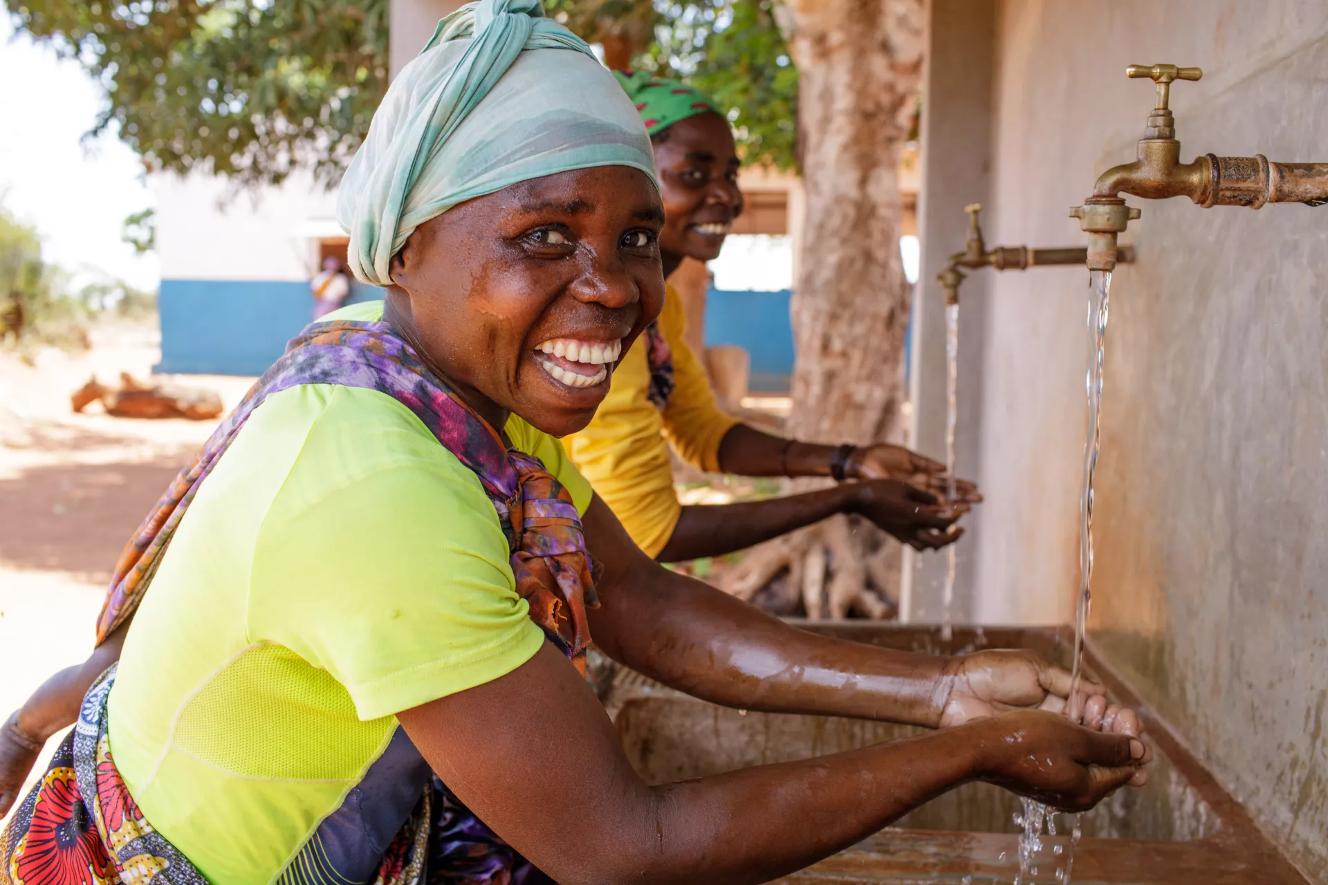 Women enjoying water on a tap